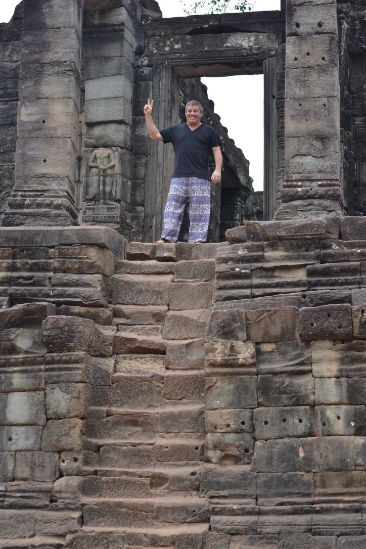 Steve Bender flashes a peace sign from the top of steep stone temple steps